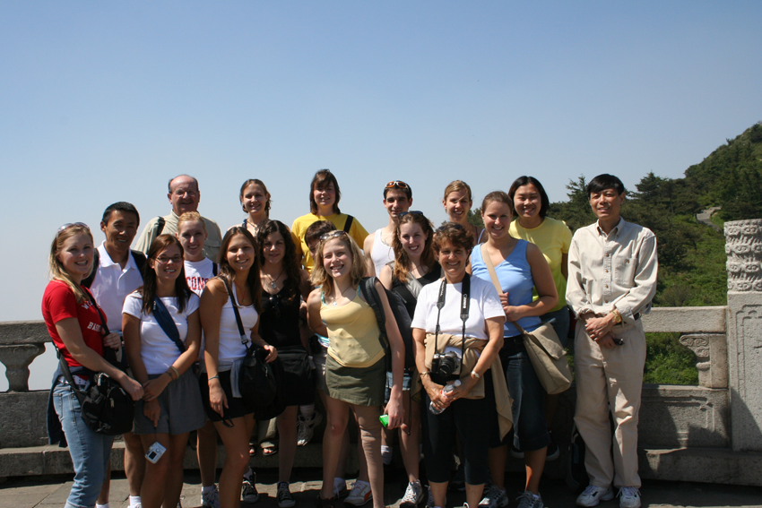 A group of students and professors standing atop a mountain in China